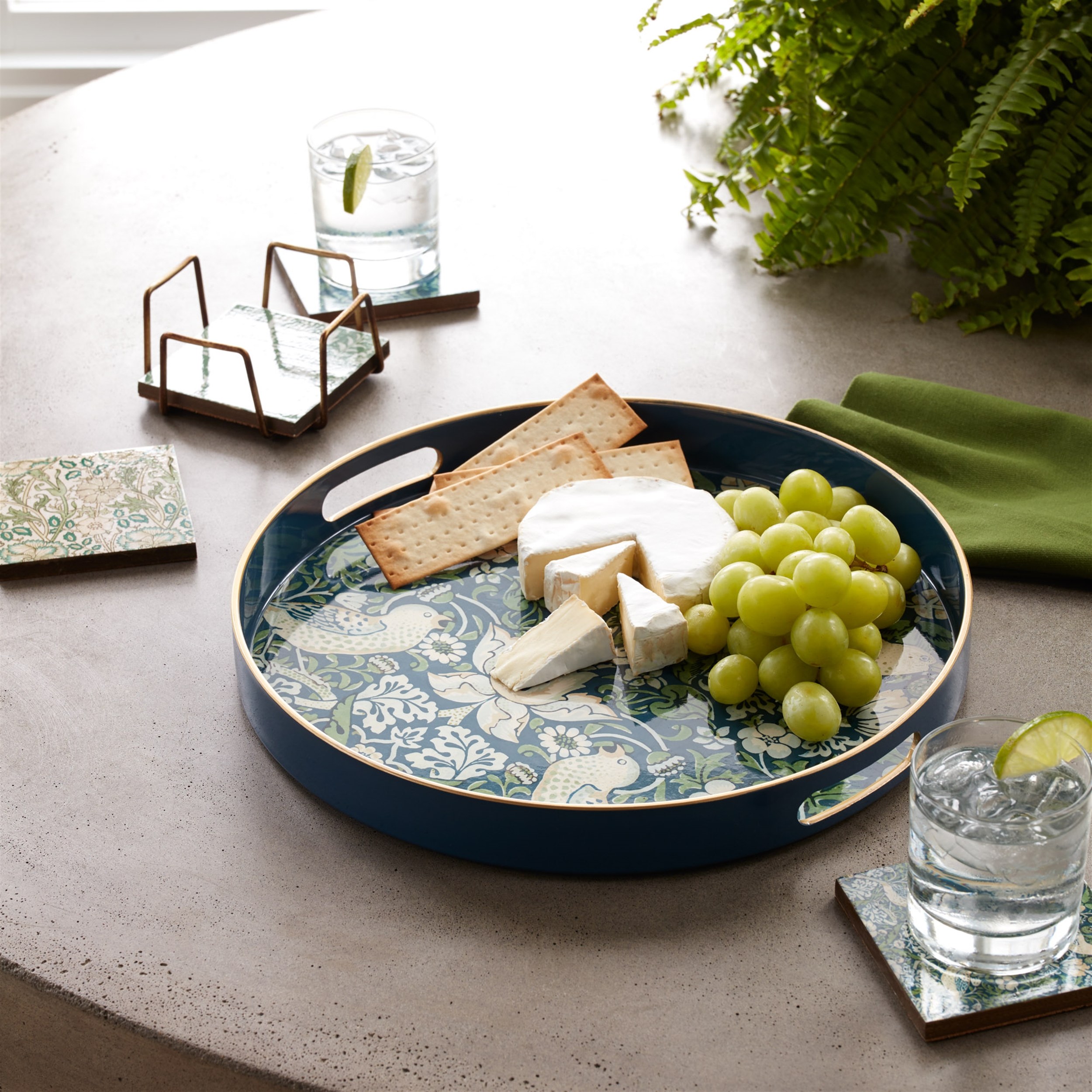Melrose International round navy serving tray styled with cheese and grapes